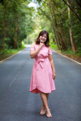 Portrait of a beautiful young woman walking on a road through a lush forest. Portrait of Asian.