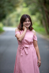 Portrait of a beautiful young woman walking on a road through a lush forest. Portrait of Asian.