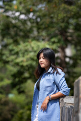 Portrait of a beautiful young woman walking on a road through a lush forest. Portrait of Asian.
