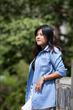 Portrait of a beautiful young woman walking on a road through a lush forest. Portrait of Asian.