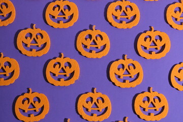 A pattern of orange pumpkins on a purple background. Background for Halloween. 
