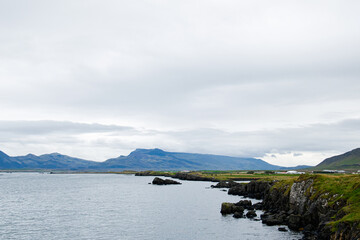 A serene coastline view with rugged cliffs and mountains in Iceland