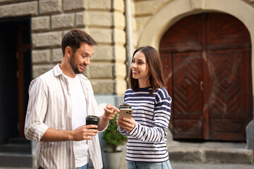 Coffee to go. Couple with paper cups of drinks outdoors, space for text