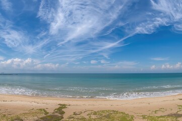Fototapeta premium Stunning summer scenery with expansive ocean view from a coastal vantage point, featuring clear skies and tranquil waves on a deserted beach