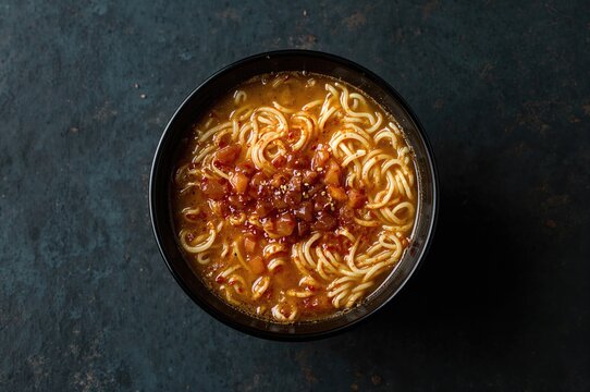 Cup of quick noodle soup seen from top, ready to eat with seasoning included