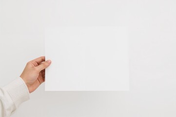 Obraz premium Sheet of paper held up against a plain white background