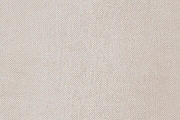 Fototapeta premium Close-up view of a finely woven textile surface featuring a light beige mesh design