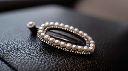 Elegant hair accessory adorned with pearls and rhinestones resting on a textured leather surface, capturing a sense of luxury and style in soft lighting.