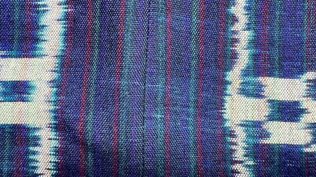 Handwoven ikat textile featuring colorful geometric patterns. Perfect for backgrounds, fashion, interior design, and cultural themes.