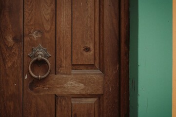 Fototapeta na wymiar Door made of wood featuring a lock and a knocker