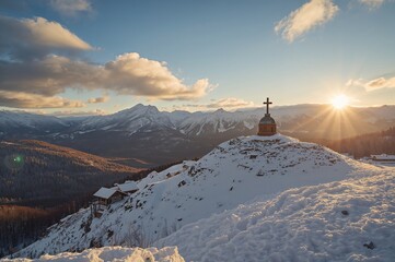 Snow-covered mountain village with a hilltop cross in a winter setting