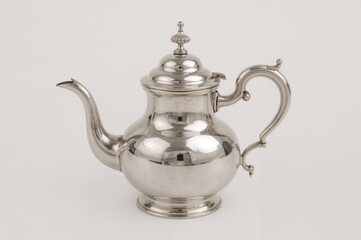 Retro silver pitcher lamp shaped like a teapot against a plain white backdrop.