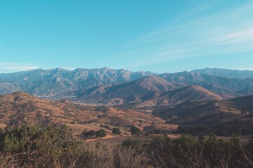 Fototapeta premium Scenic panorama of mountain ranges from a high forest trail