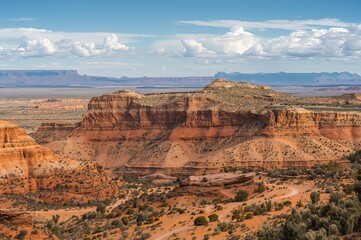 Vast plateau horizons with historic coral formations, natural arches, and rugged sandstone terrain.