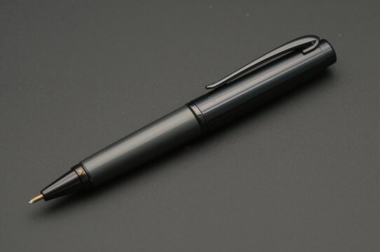 A well-worn gray ballpoint pen displaying significant use, its previously vibrant barrel now dulled and shadowed. The ink continues to flow smoothly, proving its lasting quality and dependability.