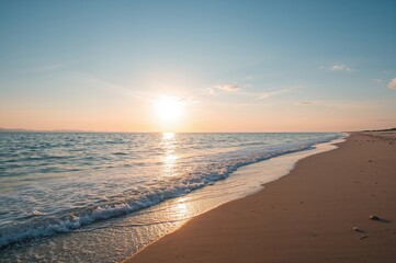 Obraz premium Coastline with expansive sky and glowing sun