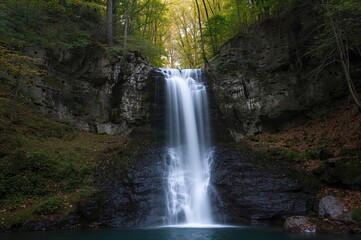 Waterfall in a lush forest park during springtime