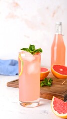 Refreshing grapefruit drink on a white surface