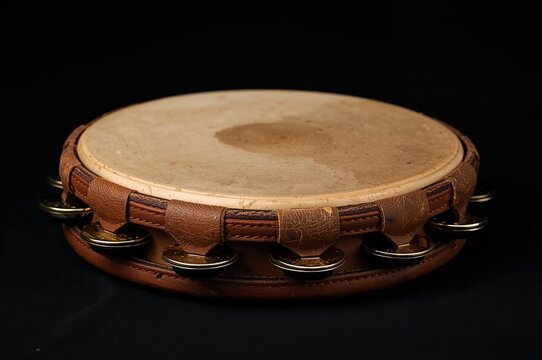 Classic hand-held percussion instrument with jingles on dark backdrop