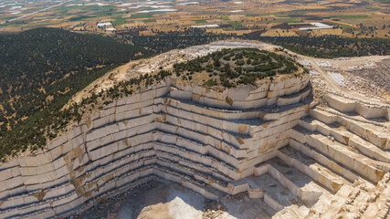 A marble quarry surrounded by forest. A strong visual and thematic contrast between the natural...