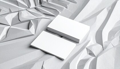 Minimalist branding mockup with blank business cards on textured sand, accented by dried florals.