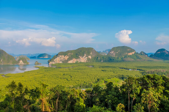 Cliffs, palm trees and sandy beach in Krabi, Thailand, with turquoise sea, limestone formations, and tropical vegetation under clear sky, showing coastal landscape travel destination in Andaman sea - Powered by Adobe
