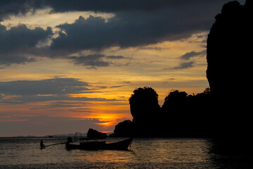 Cliffs, palm trees and sandy beach in Krabi, Thailand, with turquoise sea, limestone formations, and tropical vegetation under clear sky, showing coastal landscape travel destination in Andaman sea