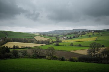 Obraz premium Scenic rural landscape featuring rolling hills and gloomy skies