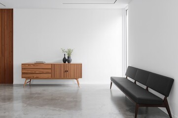 Modern lounge area featuring a wooden cabinet, dark chairs, and a polished concrete floor. Present-day Scandinavian simplicity.