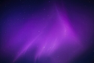 Fototapeta premium A mesmerizing aurora borealis glowing in vivid purple and pink shades, enhanced by twinkling stars in the night sky.