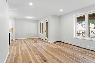 Large, empty living room with hardwood floors and white walls