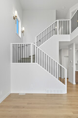 Staircase with a railing and a white wall