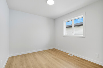 Very empty room with a window and a light