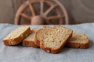Naklejka premium Close-up of four bread slices on a gray textile with a pottery grinder behind