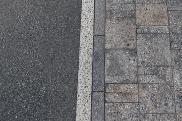 Smooth shift between asphalt and granite tiles represents the fusion of strength and sophistication, showcasing modern infrastructure and the balance between natural and built environments