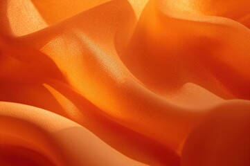 Obraz premium Close-up of detailed orange cloth with gentle creases and shading, showcasing fine textures and a cozy shine.