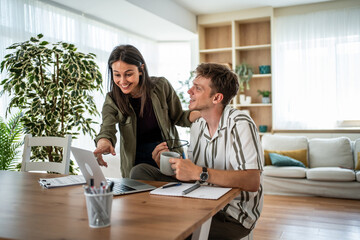 Obraz premium Couple collaborating on a laptop at home office