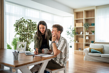 Obraz premium Young couple planning future together at home with laptop