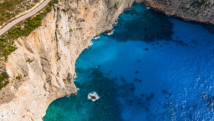 Zakynthos Greece dramatic limestone cliffs rising above deep blue Ionian Sea with shoreline and transparent turquoise water below
