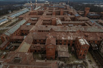 Aerial perspective of abandoned red brick structures at a former meat processing facility.