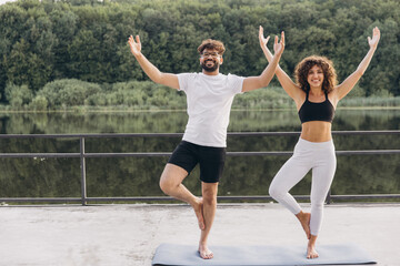 Happy arab couple practicing yoga together outdoors