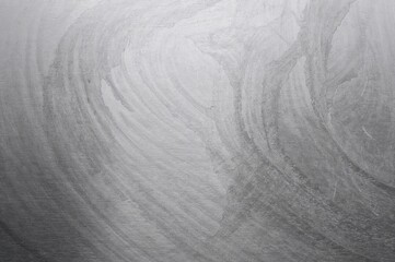 Glossy silver brushed metal panel backdrop. Abstract metallic texture surface. Polished platinum chrome sheet material.
