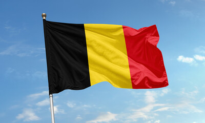 Belgium national flag with vertical black, yellow, and red stripes symbolizing unity and strength under a clear blue sky