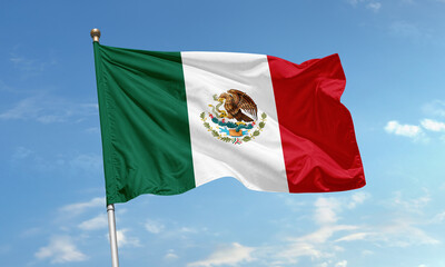 Mexico national flag waving against clear blue sky with eagle and snake emblem in center