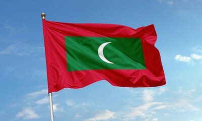 Maldives national flag with crescent moon waving under clear blue tropical sky