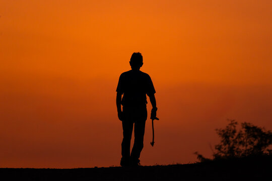 Persona mayor caminando al atardecer 