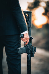 man in suit holding rifle