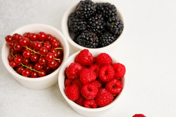 Freshly picked berries in small bowls for healthy snacking or dessert topping ideas