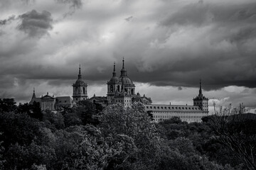 Obraz premium views of the Monastery of El Escorial and its historic gardens surrounded by autumn trees and spectacular skies.