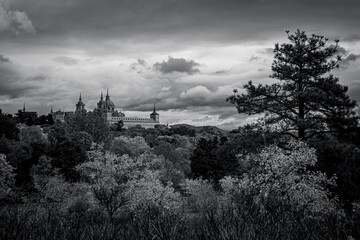 views of the Monastery of El Escorial and its historic gardens surrounded by autumn trees and spectacular skies.